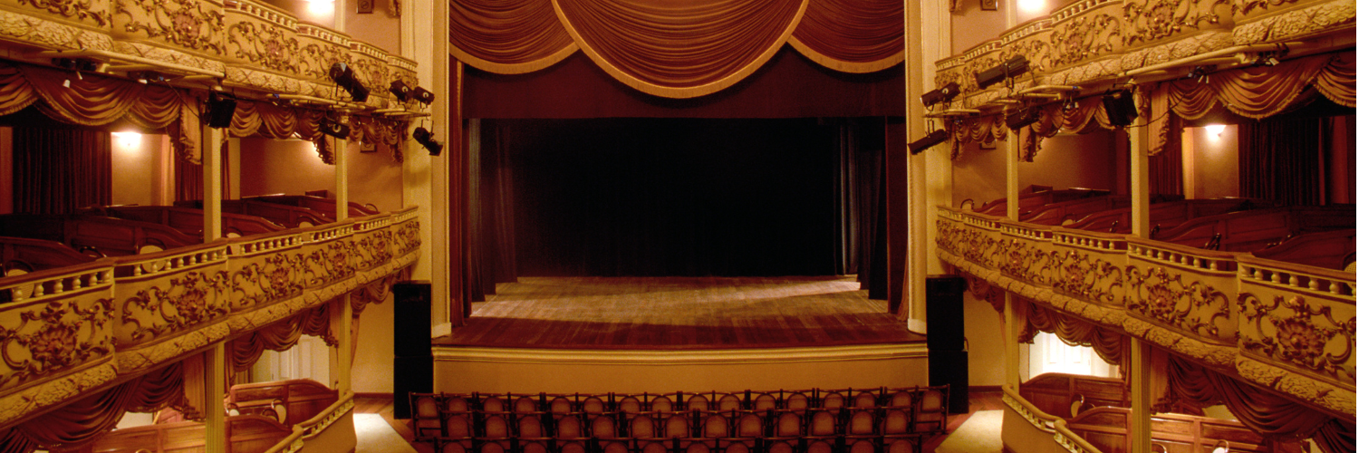 Dramatic theater stage lighting with purple and blue beams